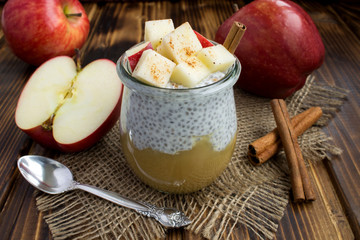 Pudding with chia, apples and cinnamon  on the rustic  wooden background