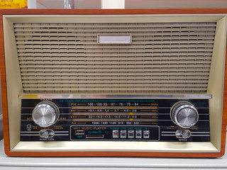 Old vintage retro broadcast radio on wood table with mint blue background .