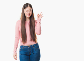 Fototapeta na wymiar Young Chinese woman over isolated background wearing glasses smiling positive doing ok sign with hand and fingers. Successful expression.