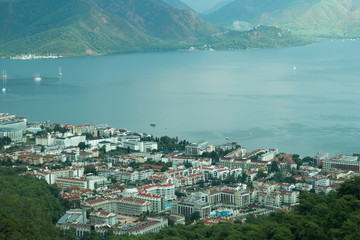 Fototapeta na wymiar Mountain town panoramic view. city between the hills with the sea