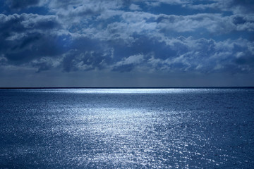 sea and sky with shimmering ocean lit by moonlight