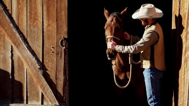Cowboy Ranch hand with horse on Dude Ranch in Corral USA