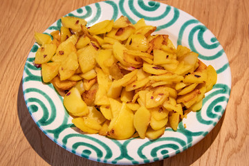 Fried Potatoes with onions on plate with green swirls
