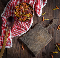 raw pasta fusilli on a brown wooden table