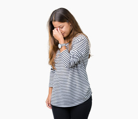 Young beautiful brunette woman wearing stripes sweater over isolated background tired rubbing nose and eyes feeling fatigue and headache. Stress and frustration concept.
