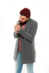 Man brutal bearded hipster dressed as vagabond smoking cigarette. Brutal unshaven guy smoking...
