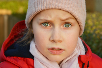 Education and parenting. Portrait of beautiful little girl smiling, wearing warm hat. Blue eyes.