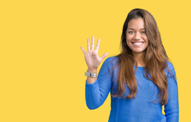 Young beautiful brunette woman wearing blue sweater over isolated background showing and pointing...