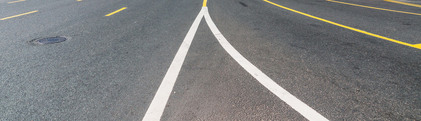 Road with white and yellow road markings and sewer hatch