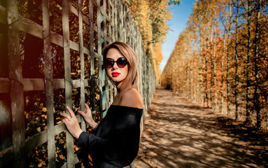 Fototapeta premium Style caucasian girl in sunglasses in autumn season park in Versailles, France