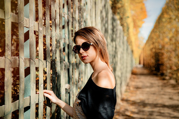Style caucasian girl in sunglasses in autumn season park in Versailles, France