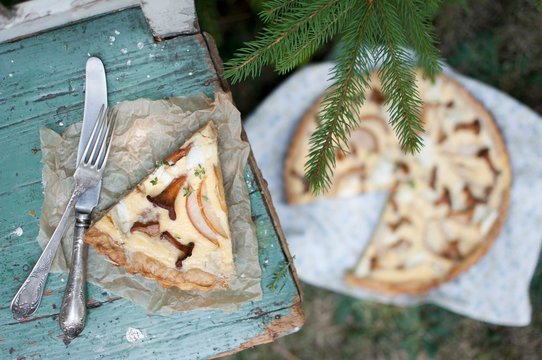 Close up of quiche slice with mushrooms on parchment paper