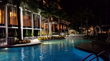 Fototapeta na wymiar Luxury Swimming Pool at Night, With Backlit Landscaping