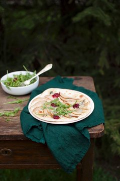 Flate bread (podplomyk) oven baked with pear, gorgonzola cheese and raspberries, served with arugula