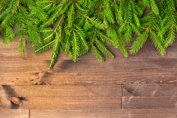 Copy space on dark wooden background. Top neatly laid out, branches of green spruce. Festive layout.
