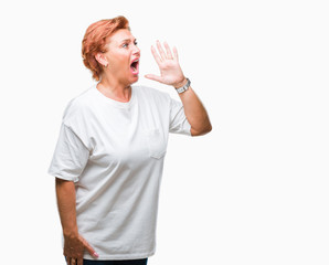 Atrractive senior caucasian redhead woman over isolated background shouting and screaming loud to side with hand on mouth. Communication concept.