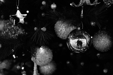 Christmas tree ornaments with a couple reflected on a ball