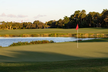 golf course with the flag in the hole with lake