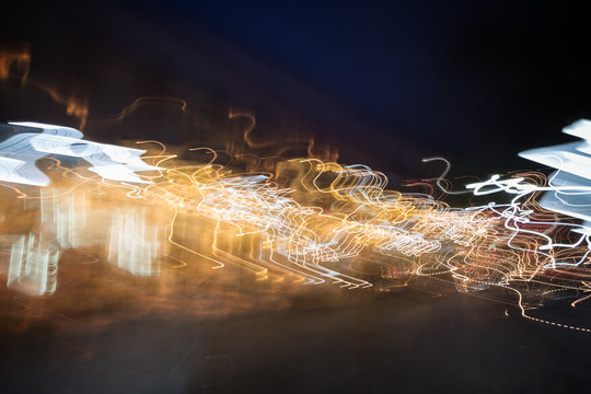 Abstract photo of motion and colorful light trails in a city at night.