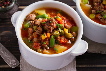 Delicious hamburger soup with vegetables: peas, corn, carrots, potatoes, tomatoes and green beans (can be cooked with frozen vegetables). horizontal