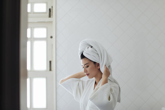 Portrait of beautiful Thai woman wearing a bathrobe and a towel on her head.