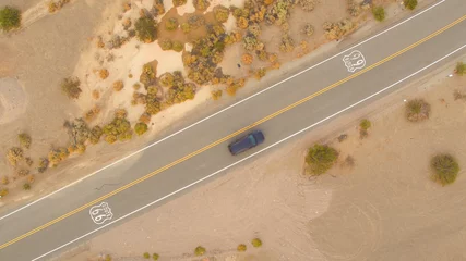 Poster AERIAL: Black SUV car on road trip driving along the historic Route 66 in USA © helivideo