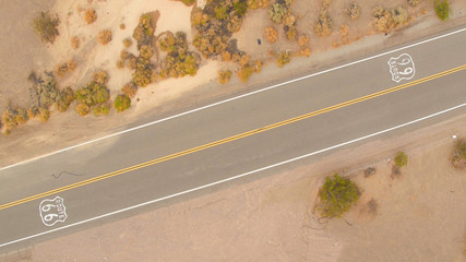 AERIAL: Black SUV car on road trip driving along the historic Route 66 in USA