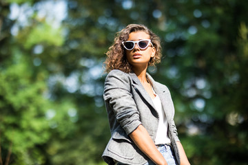 Young beautiful woman in suit and sunglasses at sunny day