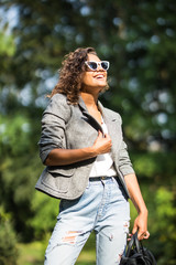 Young beautiful woman in suit and sunglasses at sunny day