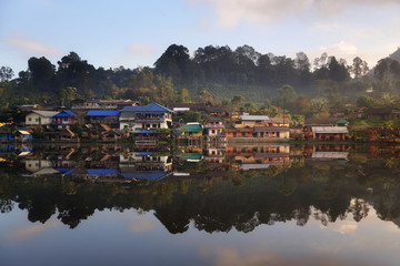 Obraz premium Beautiful scenery during sunrise with the mist and water reflection of the Chinese village at the Lee wine ruk thai lake, Mae Hong Son in Thailand is a very popular for photographers and tourists