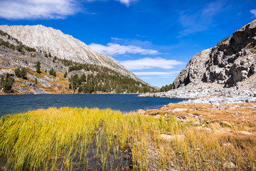 Alpine lake surrounded by the rocky ridges of the Eastern Sierra mountains; Long Lake, Little Lakes Valley trail, John Muir wilderness, California