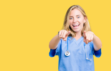 Beautiful young doctor woman wearing medical uniform over isolated background Pointing to you and...
