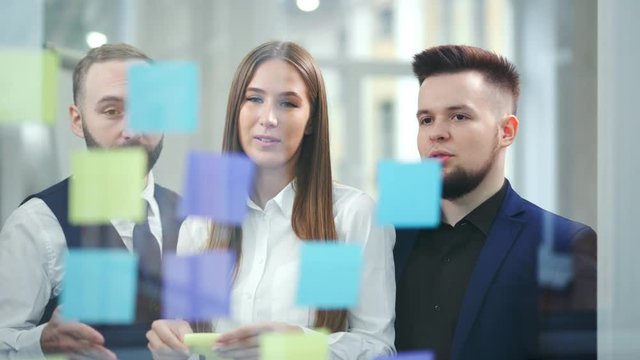 Creative businesswoman and businessman analyzing and brainstorming using multi colored sticky notes
