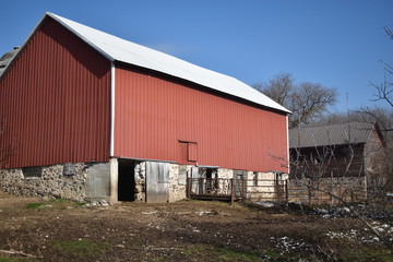 Old red barn in early winter with just a touch of snow on a sunny day on a farm