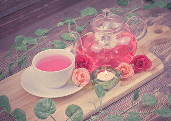 pot and cup of Rose tea on wood background