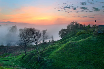 Fototapeta premium misty dawn in the valley of the hills