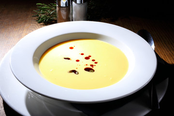 Bright yellow beautiful soup in a white plate