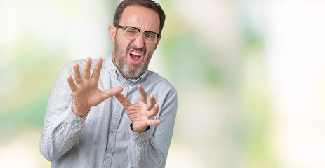 Handsome middle age elegant senior man wearing glasses over isolated background afraid and terrified with fear expression stop gesture with hands, shouting in shock. Panic concept.