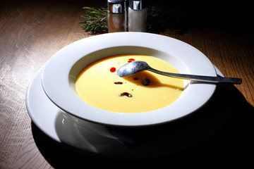 Bright yellow beautiful soup in a white plate