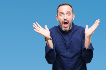 Middle age hoary senior man over isolated background clueless and confused expression with arms and...