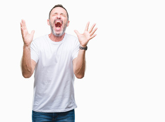 Naklejka premium Middle age hoary senior man wearing white t-shirt over isolated background celebrating mad and crazy for success with arms raised and closed eyes screaming excited. Winner concept