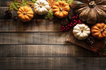 Top view of  Autumn maple leaves with Pumpkin and red berries on old wooden background. Thanksgiving day concept.