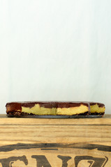 A slice of vegan cheesecake covered in chocolate