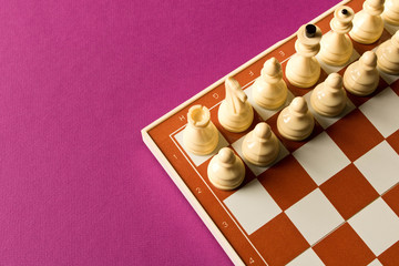 Board with white chess on purple background.  The concept of the game of chess