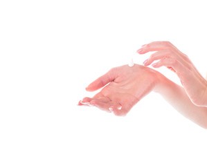 Closeup shot of beautiful female hands holding and applying moisturiser. Beauty woman's hand applying cream. Hands isolated on white background