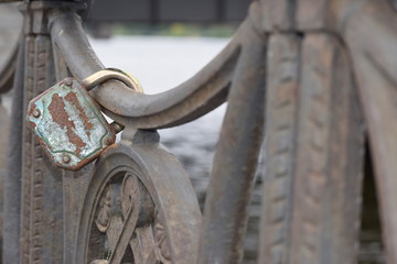 old rusty lock on the metal fence of the bridge. Valentine's day background. Tinting the image. Blurred background.