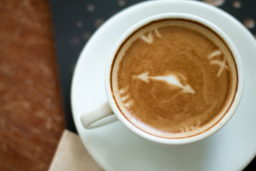 Closeup of A cup of Latte Art hot coffee over wooden  table top background in coffee's shop