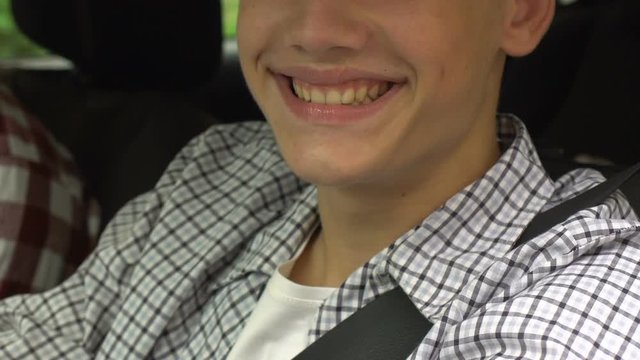 Excited smile of happy young man driving new car, auto insurance policy, closeup