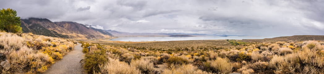 Panoramic view of the Mono Lake area; paved walking trail going towards the lake; Eastern Sierra mountains, California