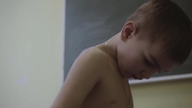 little caucasian during physiotherapy try to make basic movements